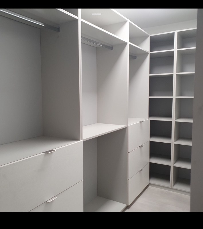 Closet blanco a medida con repisas y espacio para ropa